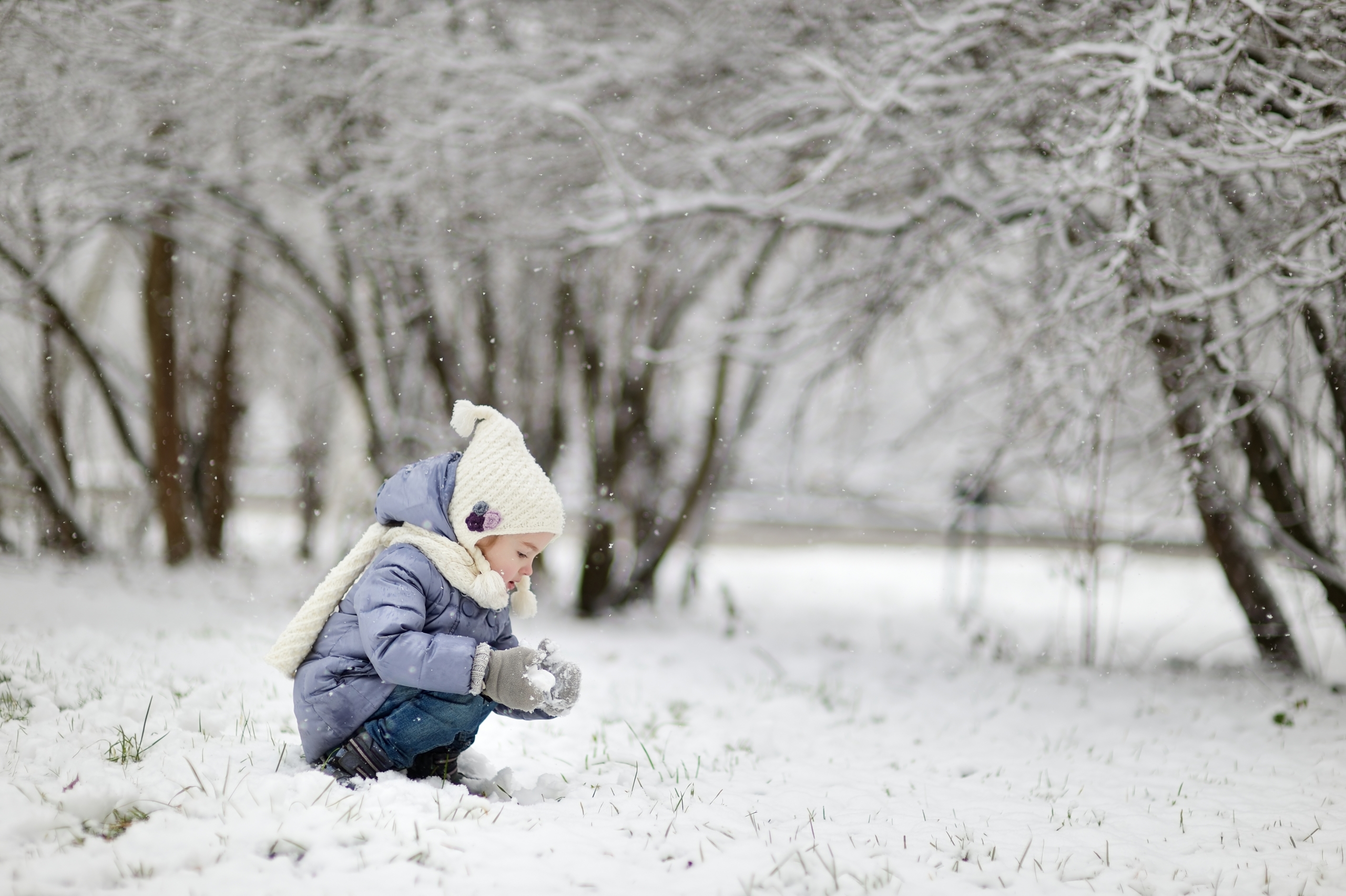 Ein Mädchen spielt im Schnee und hat Spaß an einem schönen Wintertag