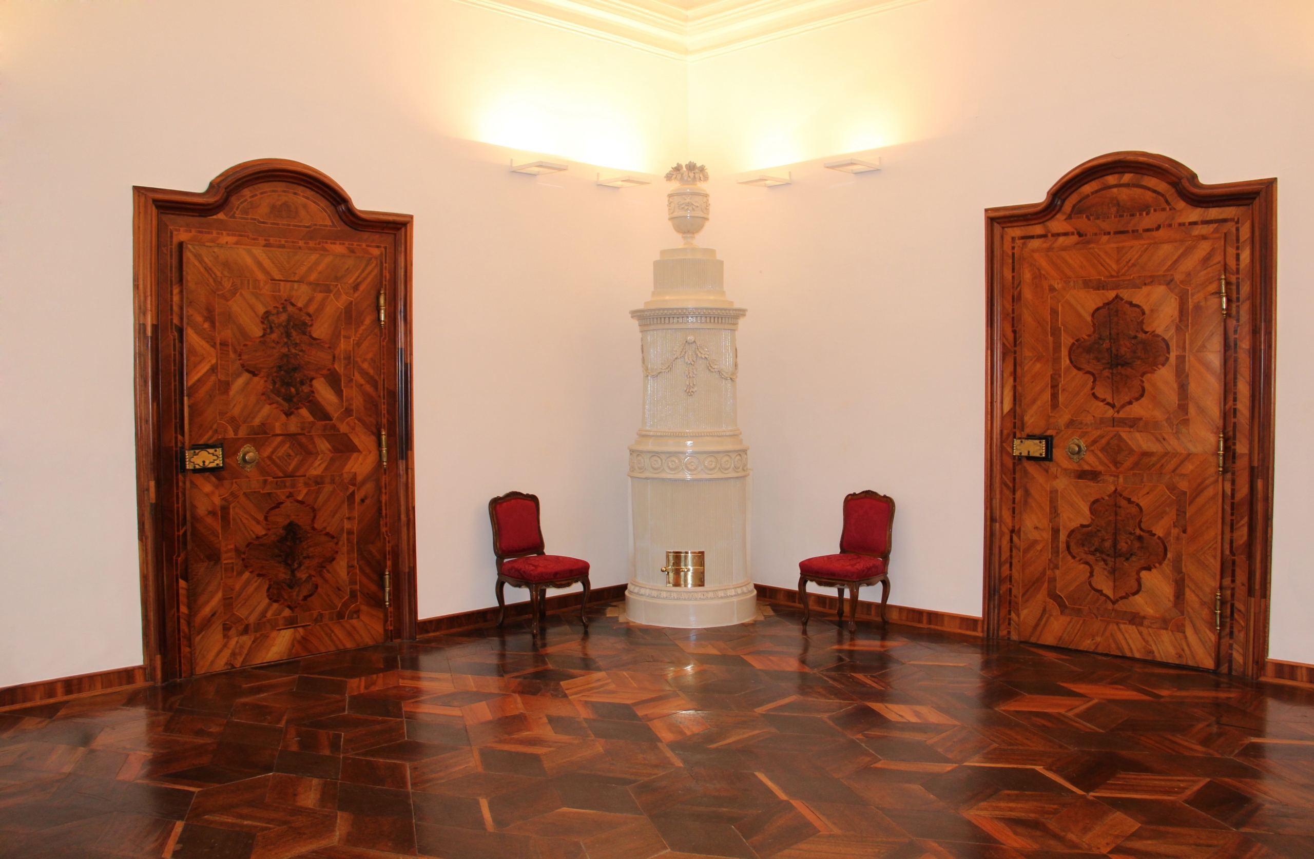 Restaurierter Kachelofen in einem holzvertäfelten Raum